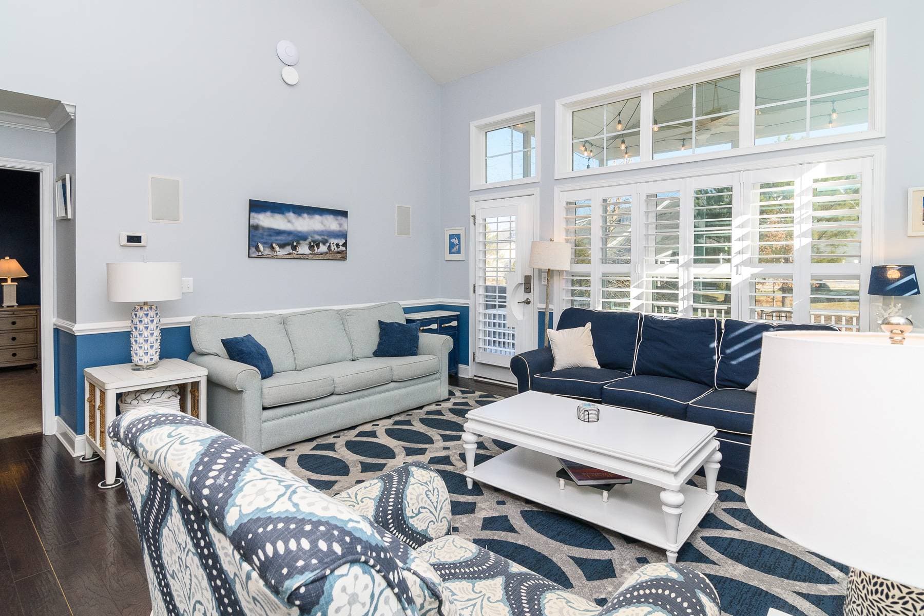 The sofa on the left side includes a queen sized sofa bed. The screened in porch is right behind that door and includes seating for 8 and festive string lights.